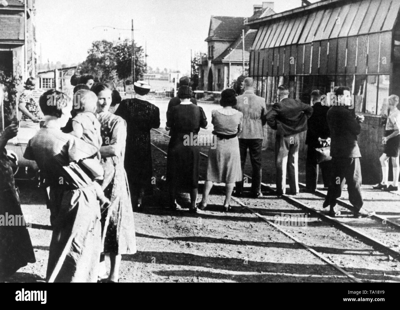 Taken shortly before the outbreak of war, this picture shows several people who had escaped from Polish violence, who, at a safe distance from a German border, were looking at the barrier and the Polish frontier soldiers, who were patrolling behind. Stock Photo