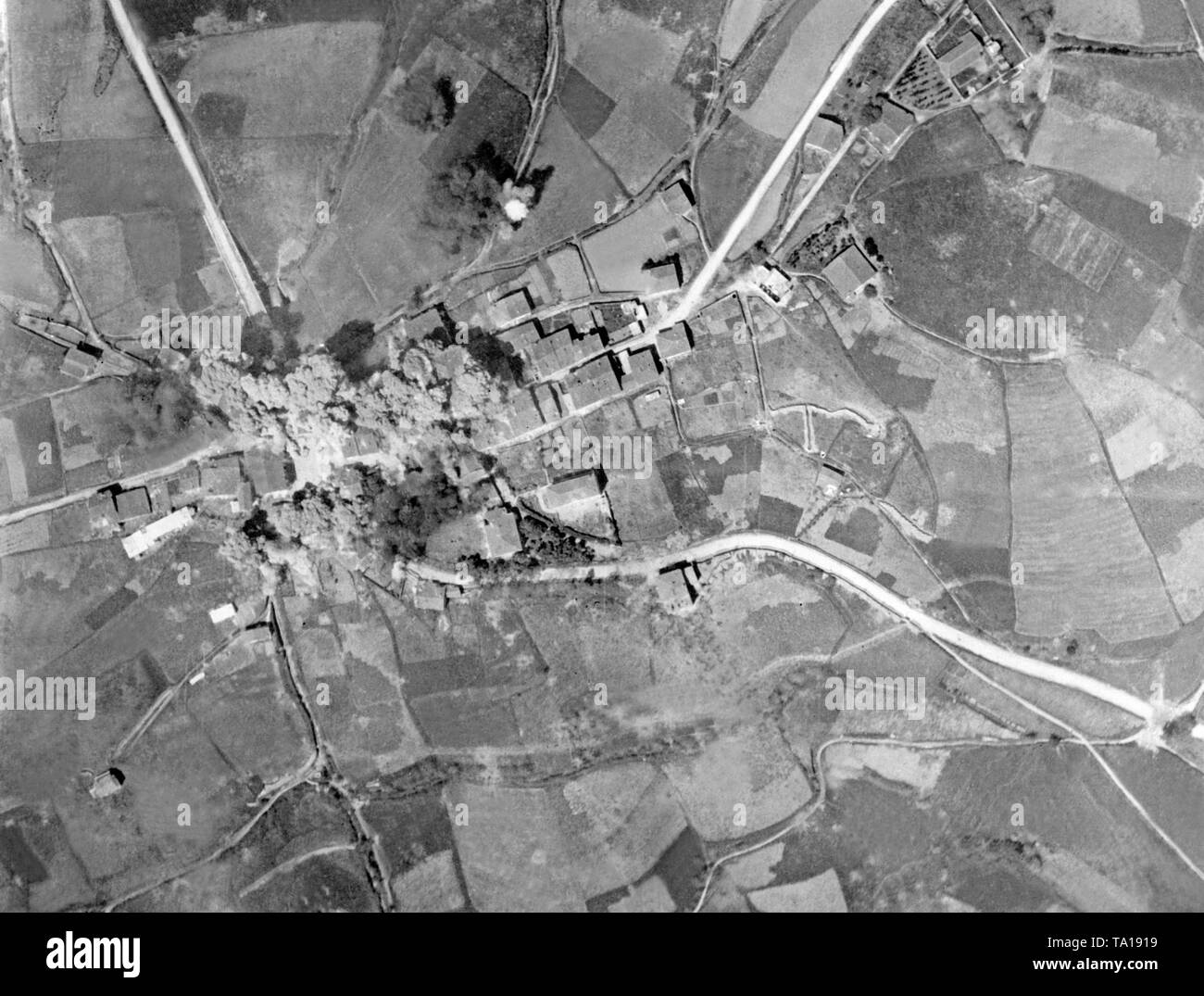 Aerial view of a bomb attack by the Italian Air Force of the Corpo Truppe Volontarie (CTV) on a village in the Spanish Civil War. Pictured, the impacts and the smoke and dust clouds of the attack. Stock Photo