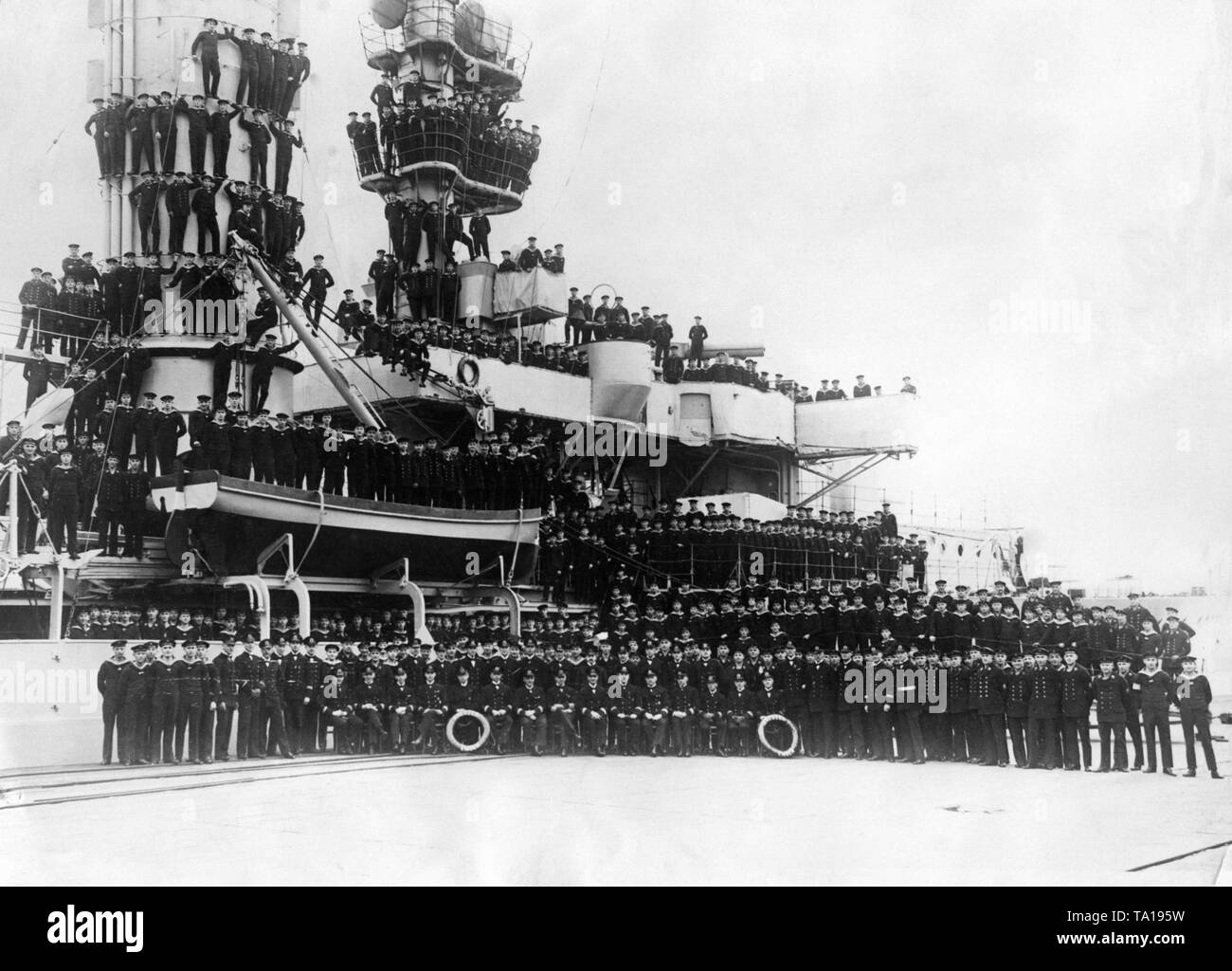 The picture shows the crew on and in front of the light cruiser 'Emden', a training ship of the Reichsmarine. The picture arose before the departure for the 2nd world tour, which lasted from 5.12.1928 to 3.12.1929. For this trip, the 'Emden' had 66 officers on board as part of the crew. Stock Photo