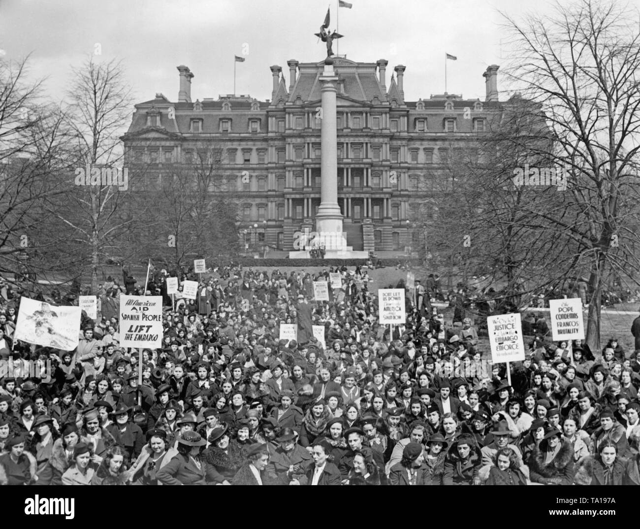 Photo of a demonstration of about 3,000 Spanish women in President's Park in front of the State Department building (in the background, now Eisenhower Executive Office Building) near the White House in Washington DC on April 4, 1938. The demonstrators (United Committees of Spanish Women in America ) carry posters on which they demand aid for Spain and the abolition of the arms embargo for the Republic. Stock Photo