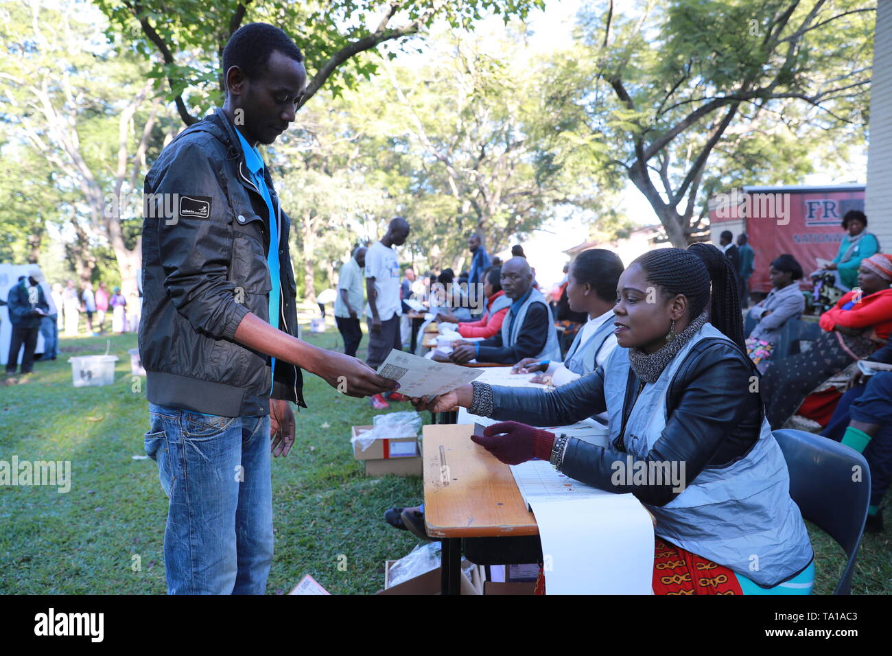 Blantyre, Malawi. 21st May, 2019. A voter receives a ballot paper at Blantyre Secondary School Polling Station in Blantyre, Malawi, May 21, 2019. Malawians across the country on Tuesday queued up to cast ballots that will determine which party is to rule the country in the next five years. Credit: Peng Lijun/Xinhua/Alamy Live News Stock Photo