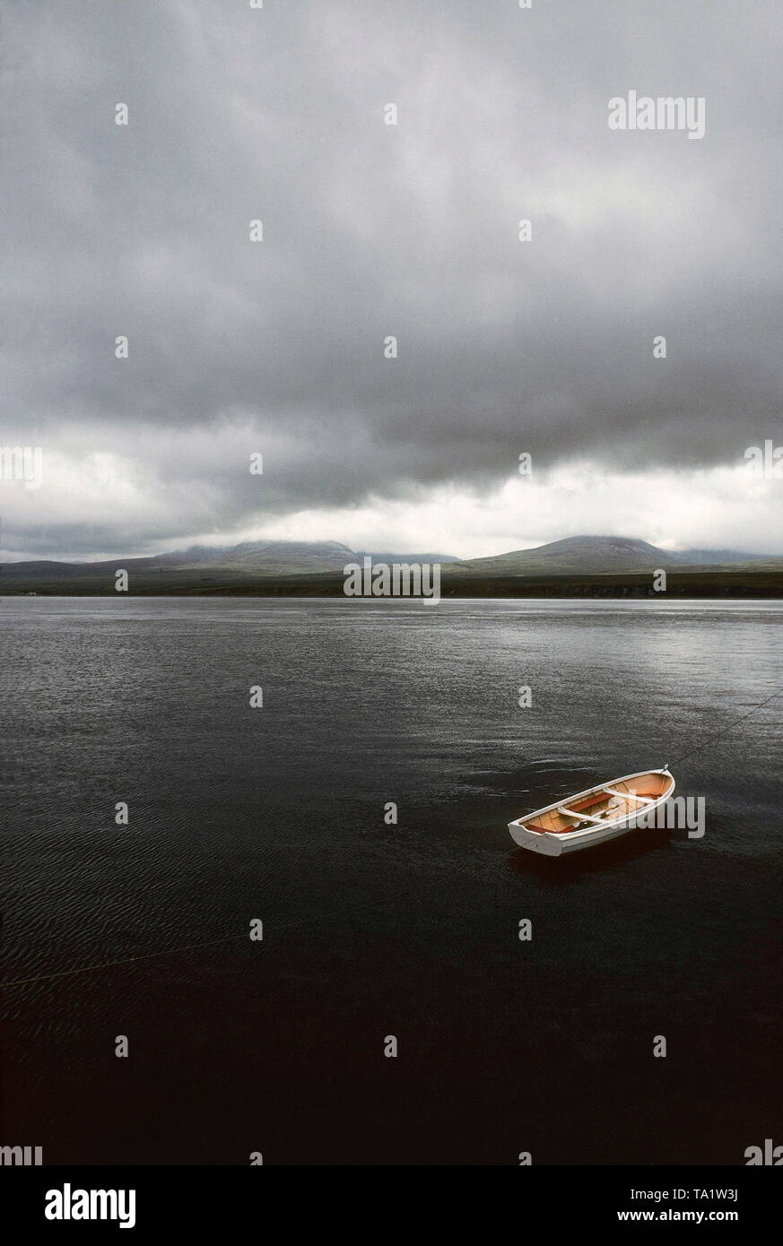 Lone dinghy, Caol Ila, Sound of Islay and Paps of Jura, Islay Stock Photo