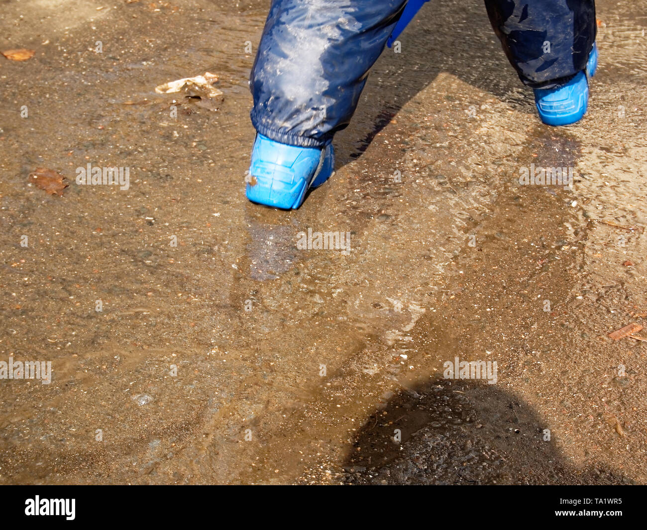 the child walks through puddles in rubber boots in the spring, Moscow ...