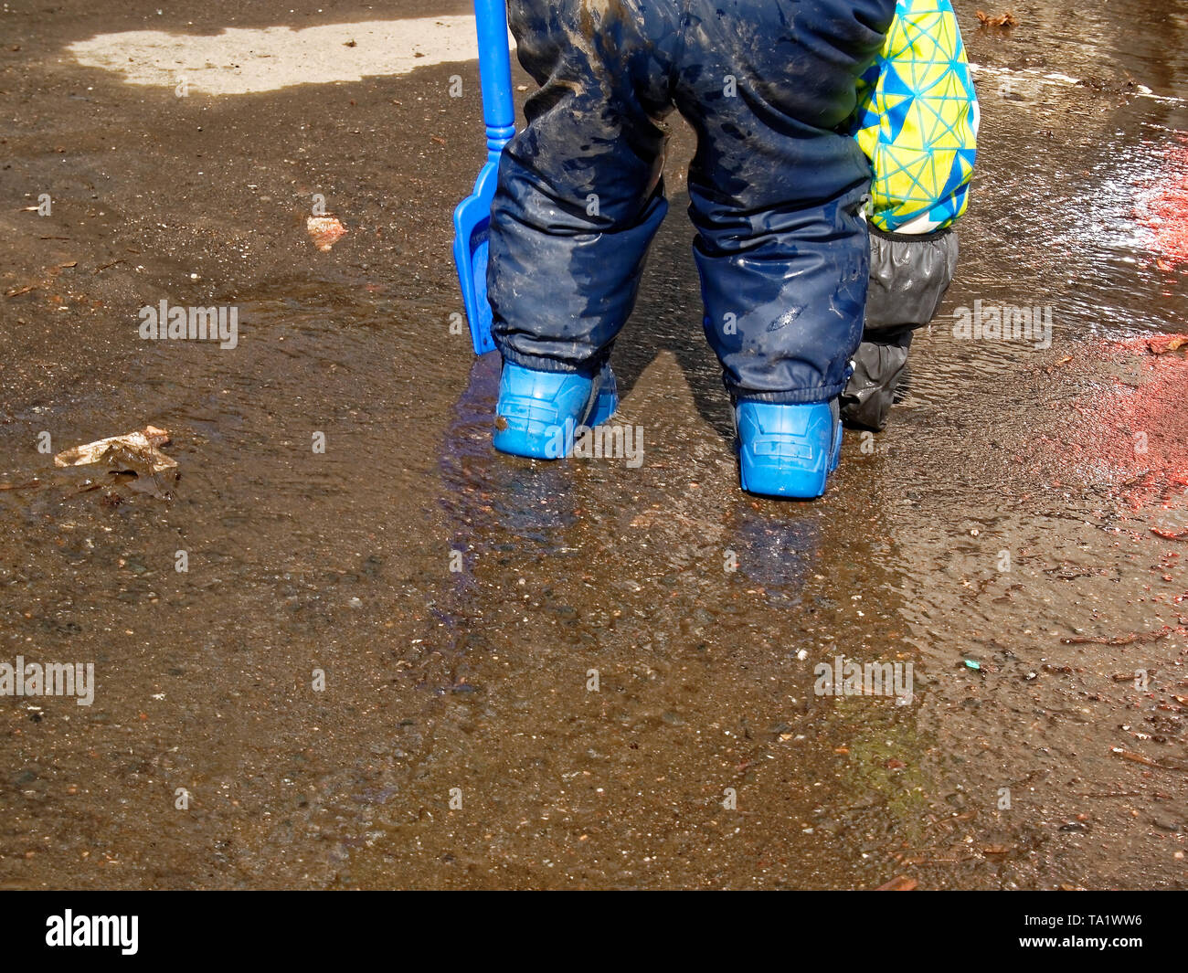 the child walks through puddles in rubber boots in the spring, Moscow ...