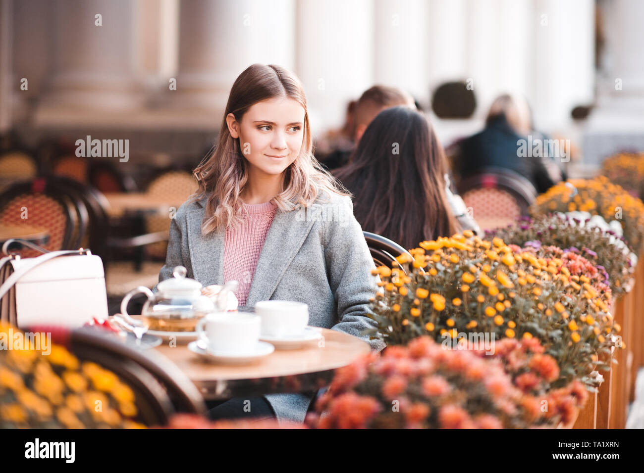 Stylish Young Girl Having Breakfast In Cafe Outdoors Autumn