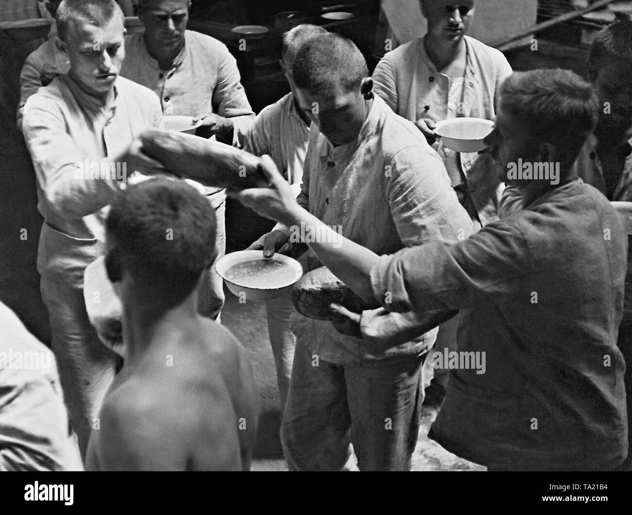 Prisoners in the Dachau concentration camp receive food. Stock Photo