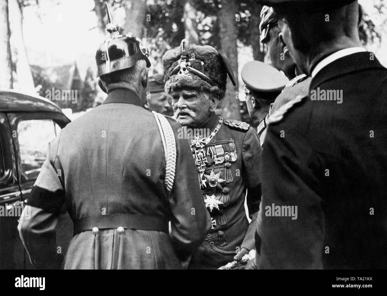 The field marshal of the Imperial Army August von Mackensen in his hussar uniform talking to an officer in the uniform of the old army, who wears a black ribbon on the upper arm. The occasion is a funeral. Stock Photo