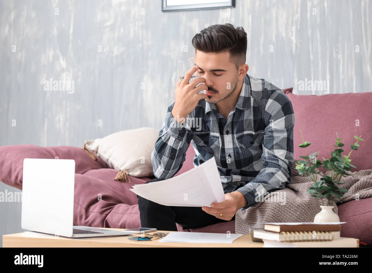 Worried young man in debt at home Stock Photo - Alamy