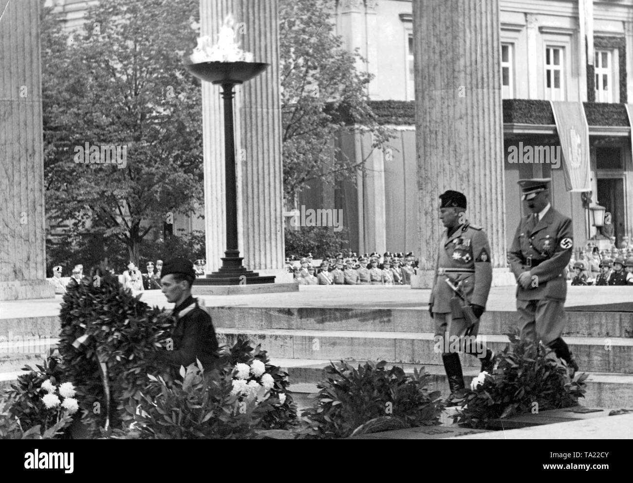 The Italian dictator Benito Mussolini on a visit to Adolf Hitler in Munich in September 1937. The 'Duce' is laying wreaths in the Ehrentempel accompanied by the 'Fuehrer'. In the background, the 'Brown House'. Stock Photo