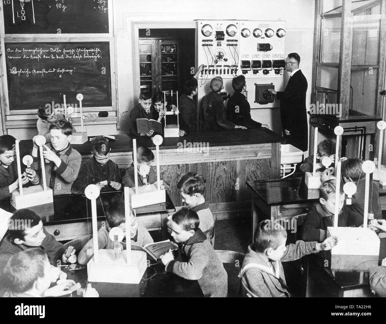 The 'Ideal school' in Kaulsdorf, Berlin, Germany in 1928. A new school was set up according to the most modern principles. In addition to ordinary classrooms there was a public library, workshops, school kitchen and reading room. The picture shows a physics class with electrical panel Stock Photo