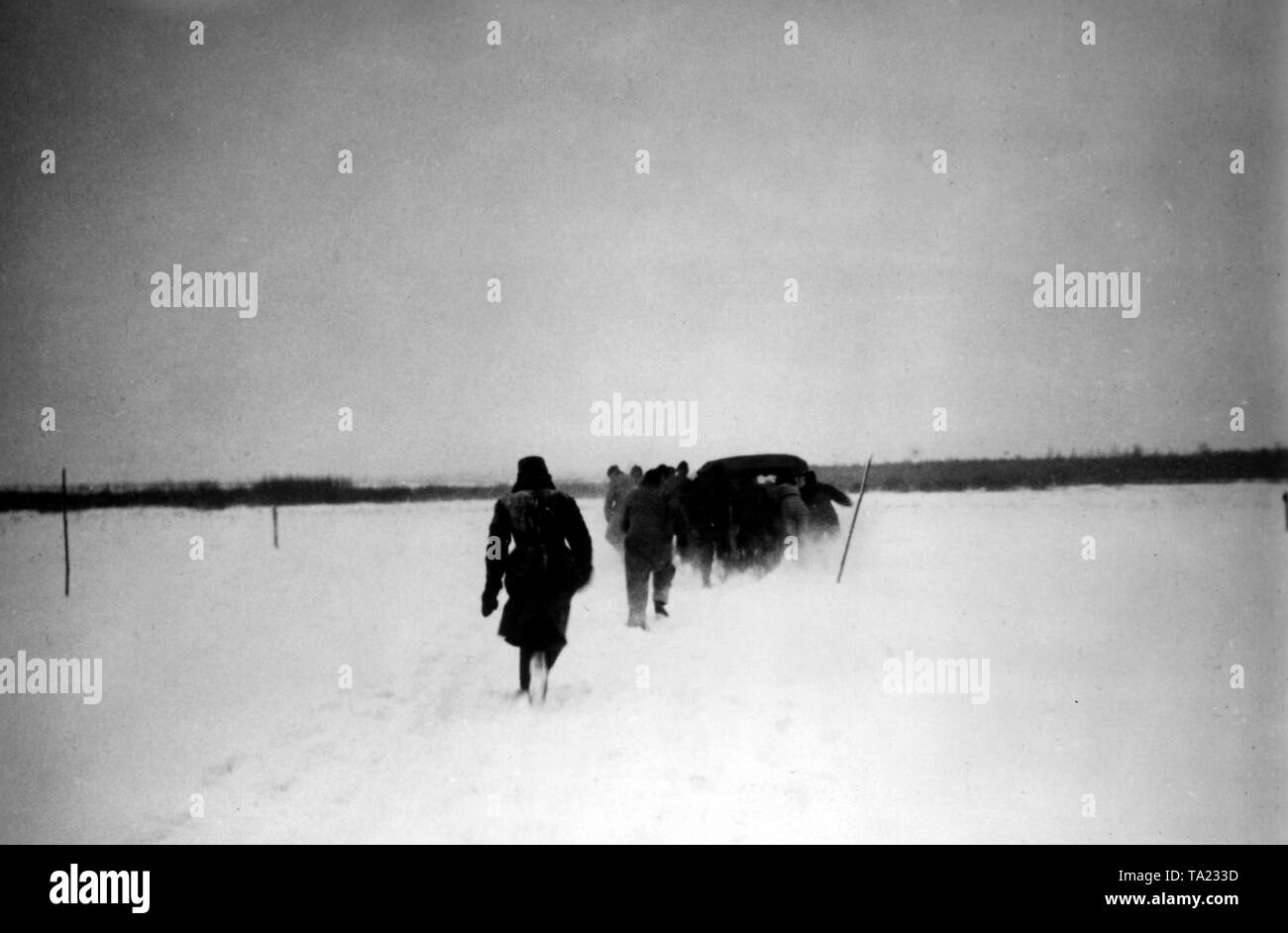 In a snow storm west of Moscow, several men, probably Wehrmacht soldiers or officials, try to free a car stuck in the snow. (PK photo: war correspondent Kling). Stock Photo