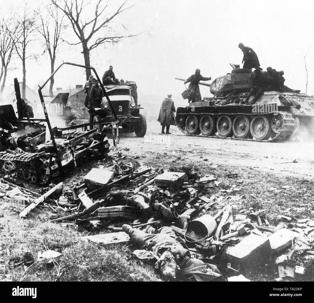 Russian T-34 tank at Berlin. Second World War, Battle of Berlin in 1945. The defensive ring around the imperial capital has collapsed. The tanks of the Red Army advance toward the city, passing by dead German soldiers and ruined defensive positions. Stock Photo
