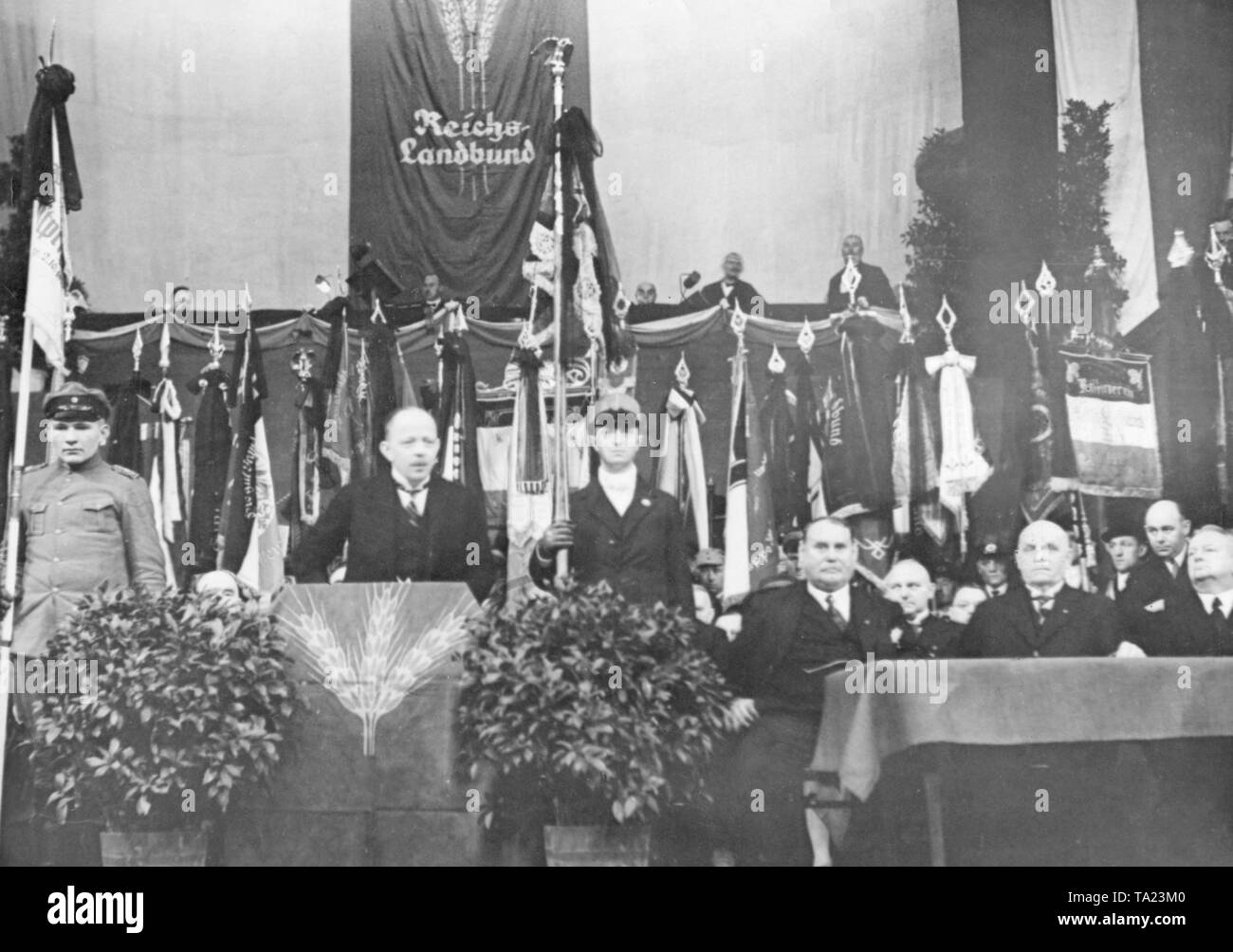 The President of the Reichslandbund (RLB), Eberhard Graf von Kalckreuth, holds an opening address in the Circus Busch, in which he announced the strongest opposition to the government of Heinrich Bruening. On the lectern is the symbol of the RLB, a grain ear. Stock Photo