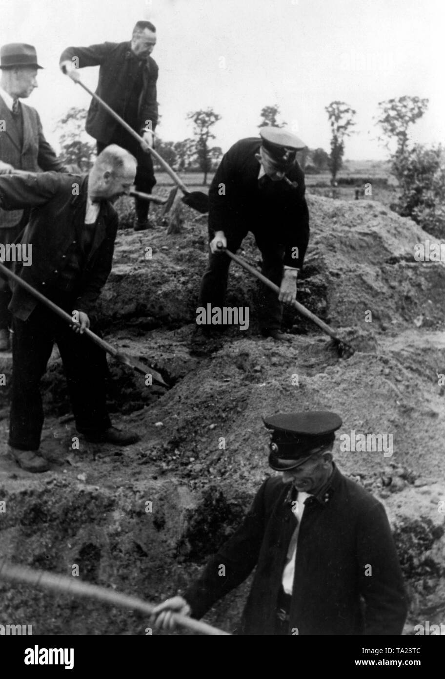 German civilians, who had been enlisted to dig trenches, setting up tank ditches on the border with Holland. Stock Photo