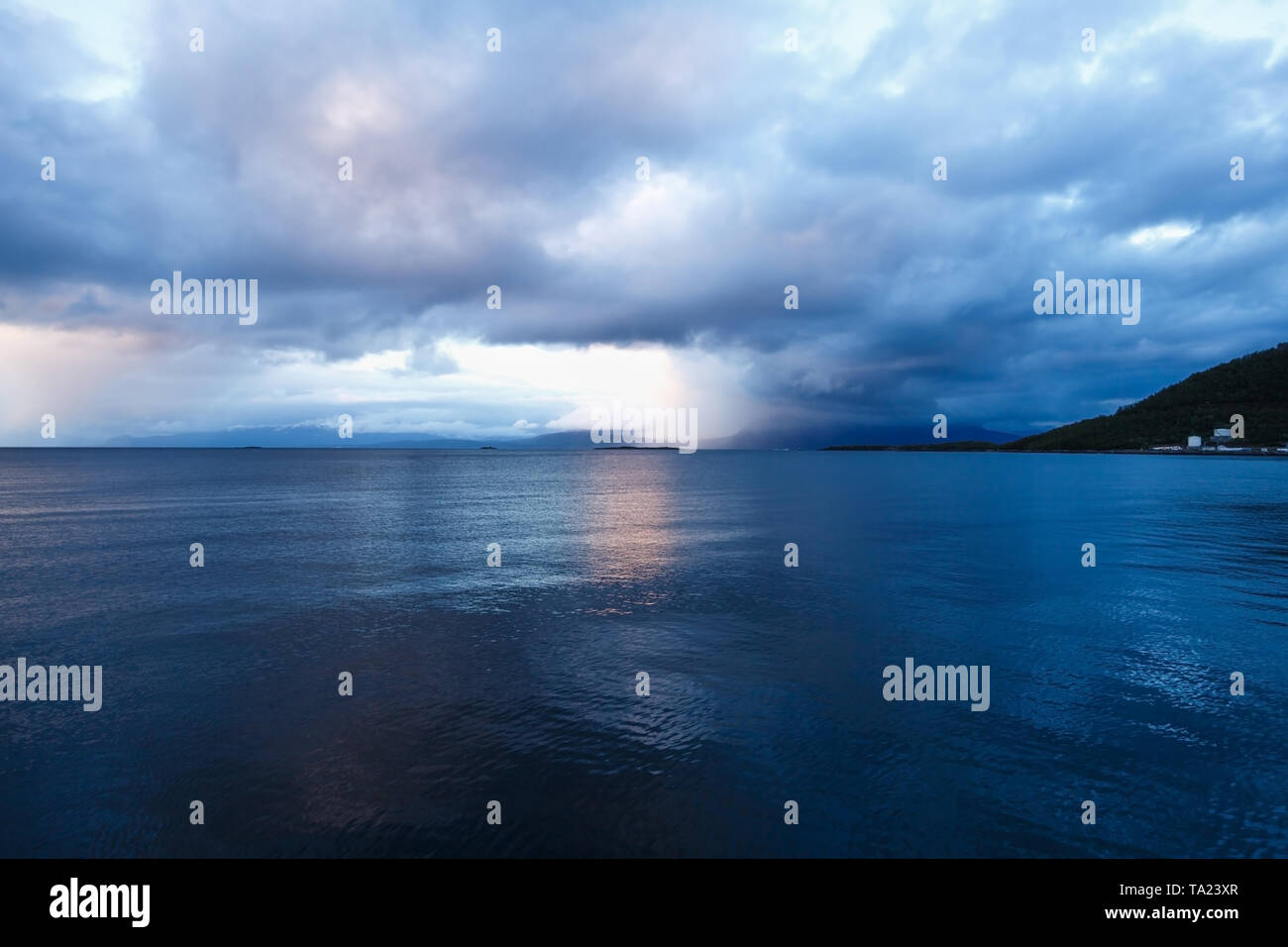 Landscape with sea and clouds in the midnight of polar day in Harstad, Norway. Stock Photo