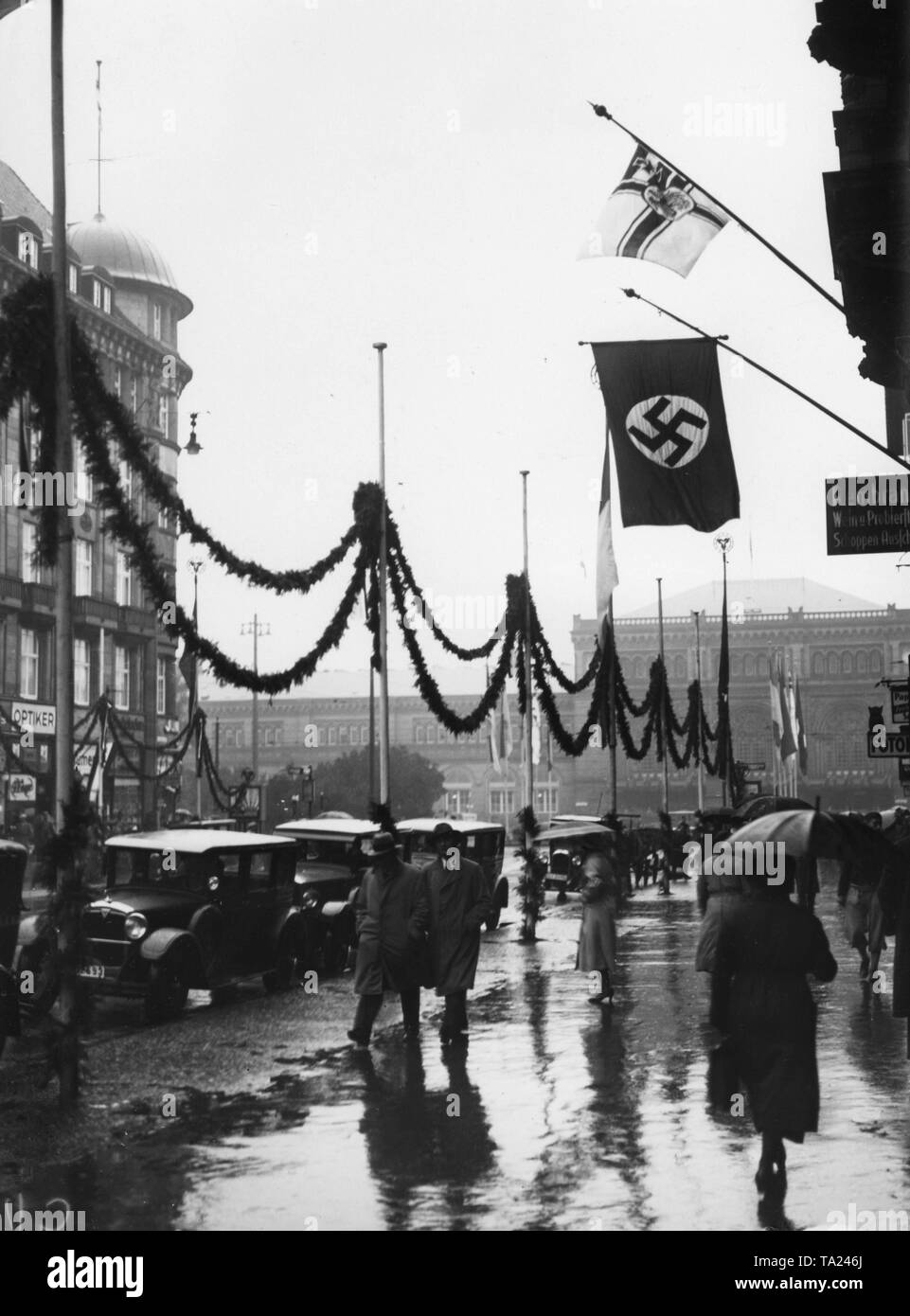 At the beginning of the Reich leadership meeting of the Stahlhelm in Hanover, the Adolf-Hitler-Strasse (today Bahnhofstrase) is decorated with garlands and flags. In the background, the Hannover Hauptbahnhof. Stock Photo