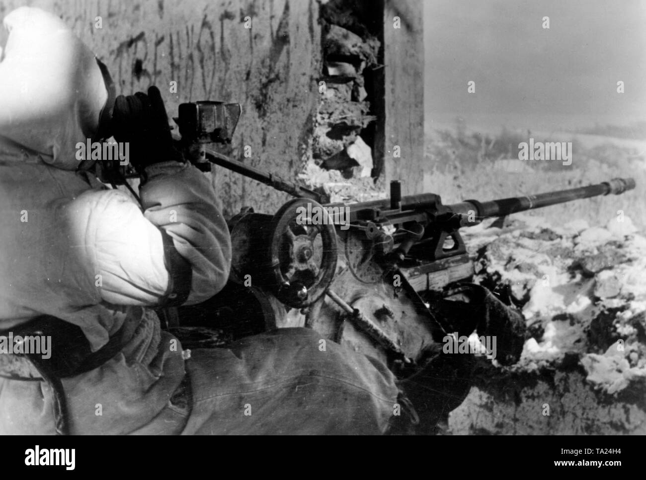 A German soldier observes the surroundings out of a ruin on a small hill. He sits on a 2 cm flak 30 which was intended for ground targets. Photo of the Propaganda Company (PK): war correspondent Liedtke. Stock Photo