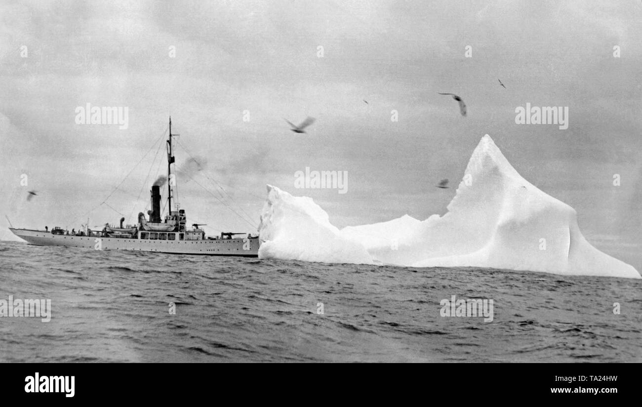 A cutter of the US Coast Guard approaches an iceberg. The International Ice Patrol was founded after the sinking of the 'Titanic' to monitor the spread of ice fields. Stock Photo