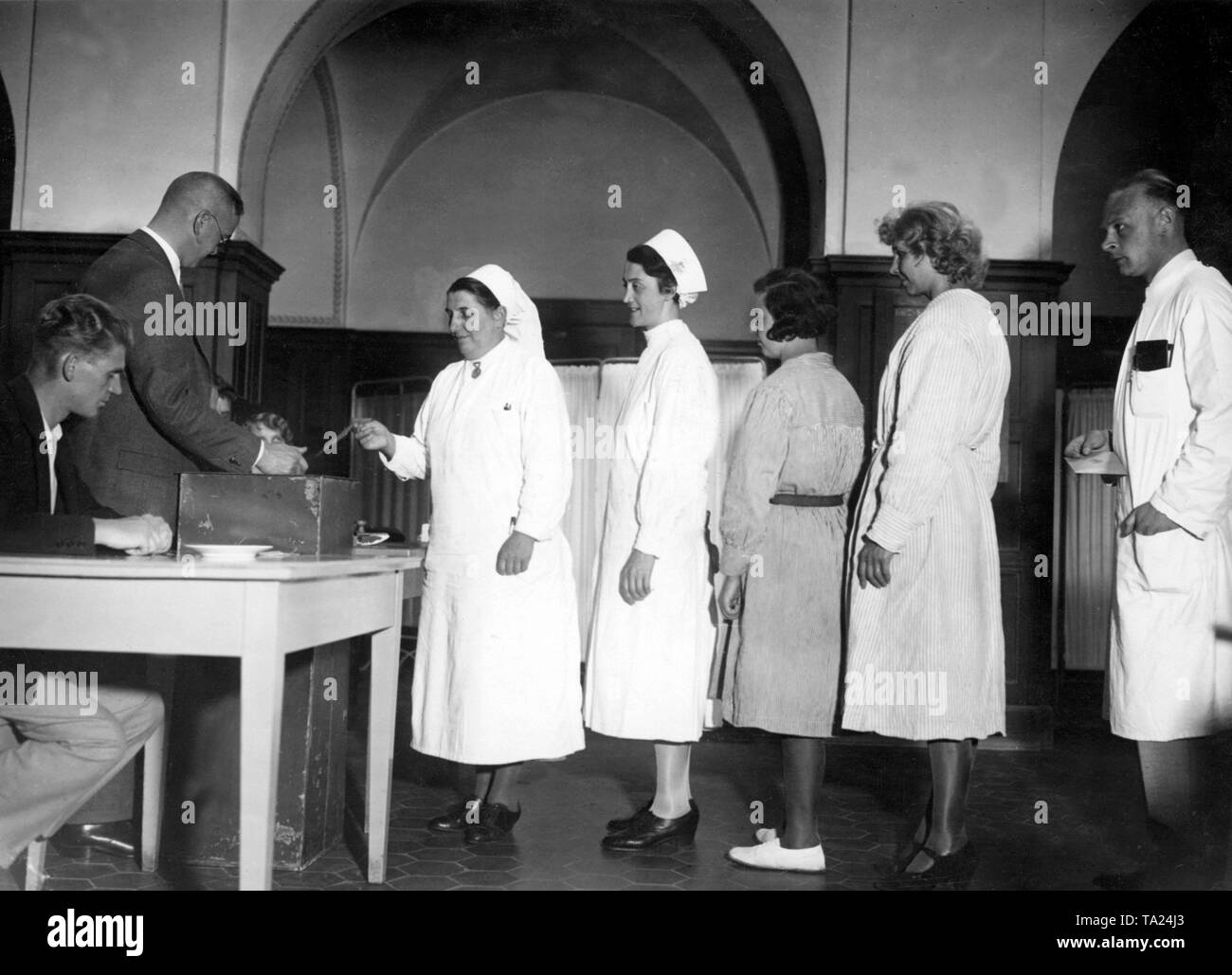 Physicians, nurses and patients are voting at a hospital during the Reichstag elections in 1932. Stock Photo