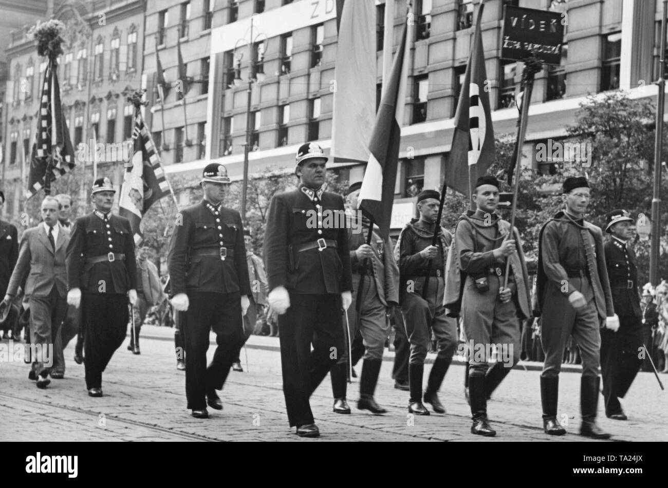 Congress of the Sokol movement in Prague. A parade will take place in the course of the event at Wenceslas Square. The Wiener Sokol Gruppe (Vienna Sokol Group) carries a swastika flag and the Czech flag. The swastika flag is accompanied by state troopers. The Sokol movement was a national and patriotic gymnastics organization. Stock Photo