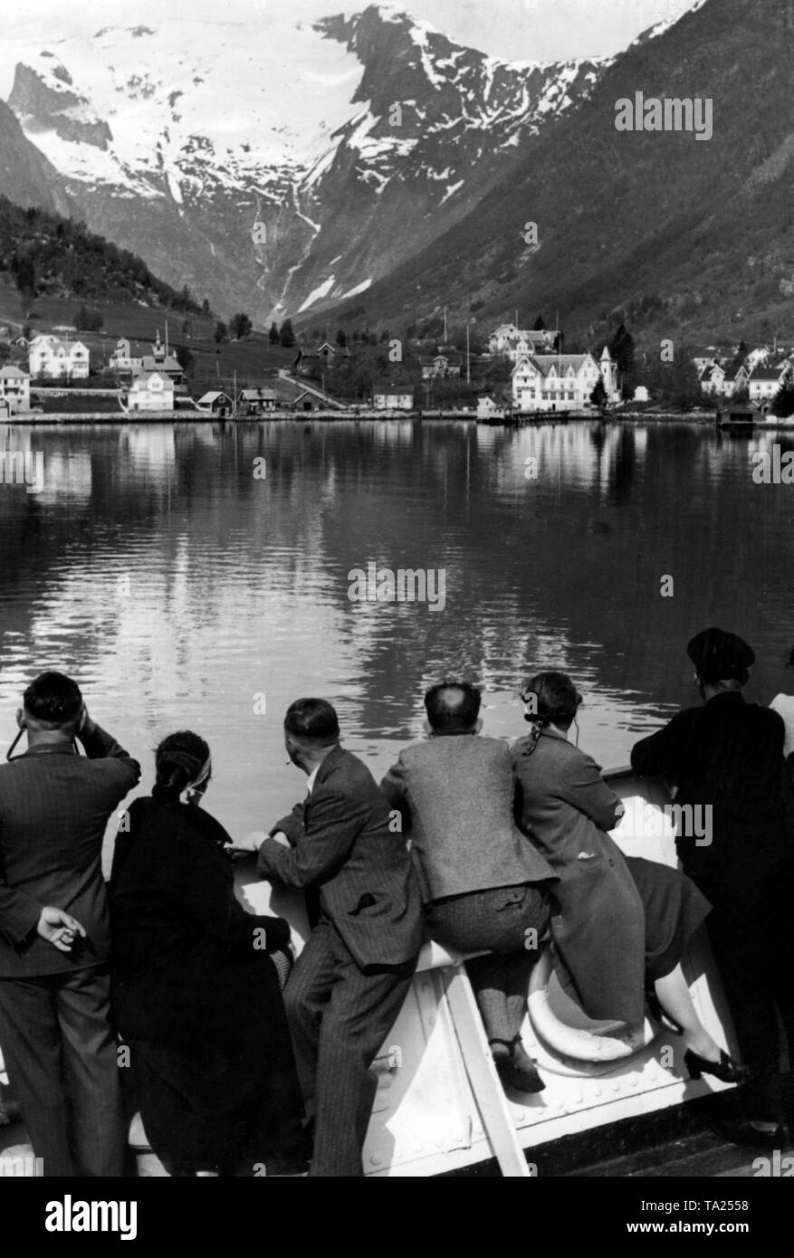 Undated photo of vacationers of the Nazi organization 'Kraft durch Freude' ('Strength through Joy') during a trip to Norway, here in a fjord on the North Sea coast. In the background, snow-covered mountains. Stock Photo