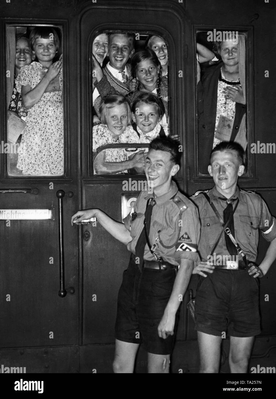 Children who had participated in the Landverschickung program ('relocation of children to the countryside') of the NSV in the Gau-Halle-Merseburg, on their return to Berlin on the Anhalter Bahnhof. Two of the youths wear uniforms of the HJ Kurmark. Stock Photo