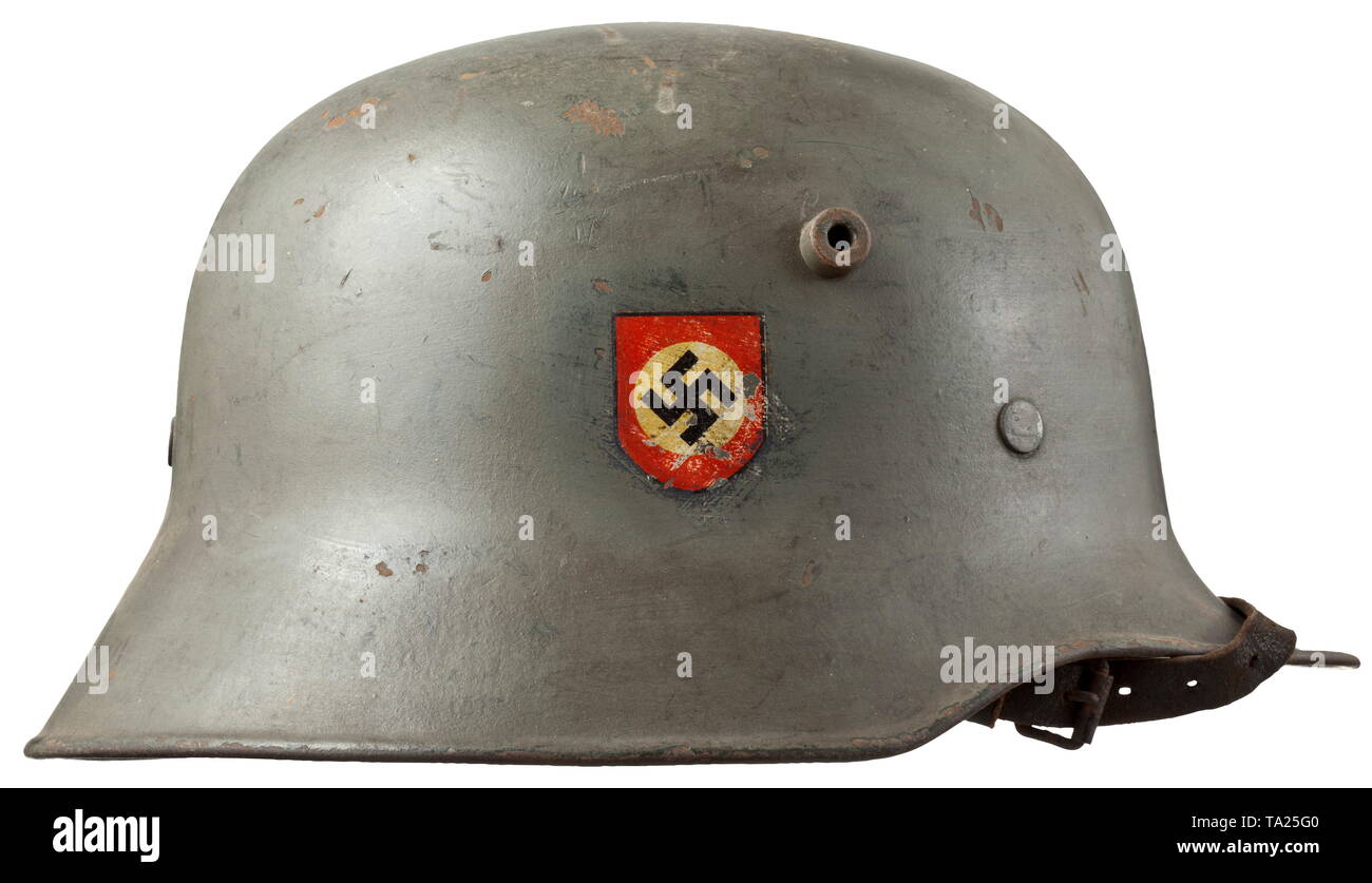 A steel helmet M 18 for members of the police divisions Feldgrau lackierte Stahlglocke mit beiden Emblemen (jeweils zu etwa 90% erhalten), unter dem Hakenkreuz-Emblem noch das Hakenkreuz der Landespolizeigruppe schwach zu erkennen. Innenfutter M 31 komplett mit Kinnriemen. historic, historical, 20th century, Additional-Rights-Clearance-Info-Not-Available Stock Photo