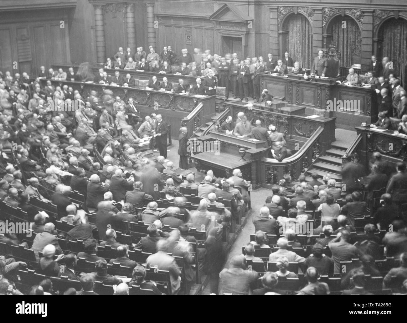 Chancellor Franz von Papen (on the government bench standing) wants to speak while Hermann Goering is (top right) stands in front of the chair of the President of the Reichstag. On the government bench sitting next to Papen, from right to left: Minister of Foreign Affairs Konstantin Freiherr von Neurath, Minister of the Interior Wilhelm Freiherr von Gayl, Economy Minister Hermann Warmbold as well as Reich Defence Minister Kurt von Schleicher. Stock Photo
