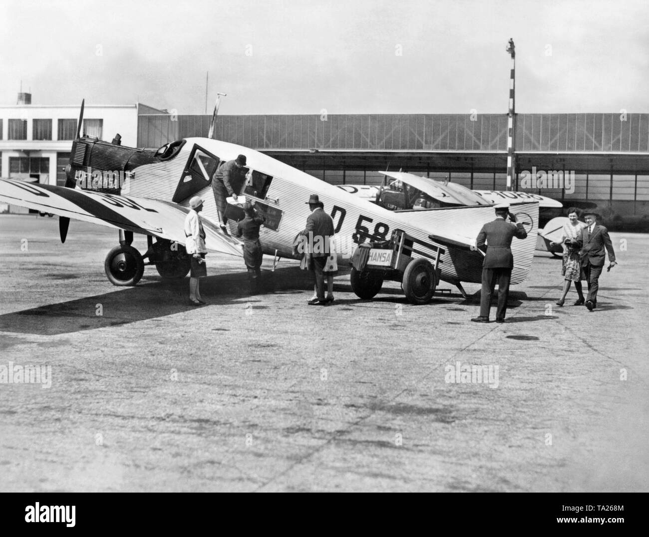 Passengers board a Junkers F 13 of the Lufthansa with the registration D-582. The F 13 was the first passenger aircraft made entirely of metal, and with more than 40 pieces it was the most common type of aircraft in the Lufthansa fleet. Stock Photo