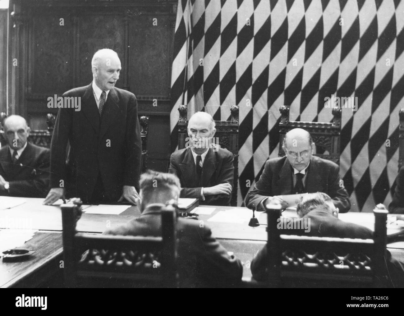 During the first council meeting in the small meeting hall of the Munich Town Hall, police president Pitzer (?) holds a speech. On the far right Lord Mayor Karl Scharnagl, who was appointed by the Allies. In the center Franz Stadelmayer, second mayor and head of the city administration. Stock Photo