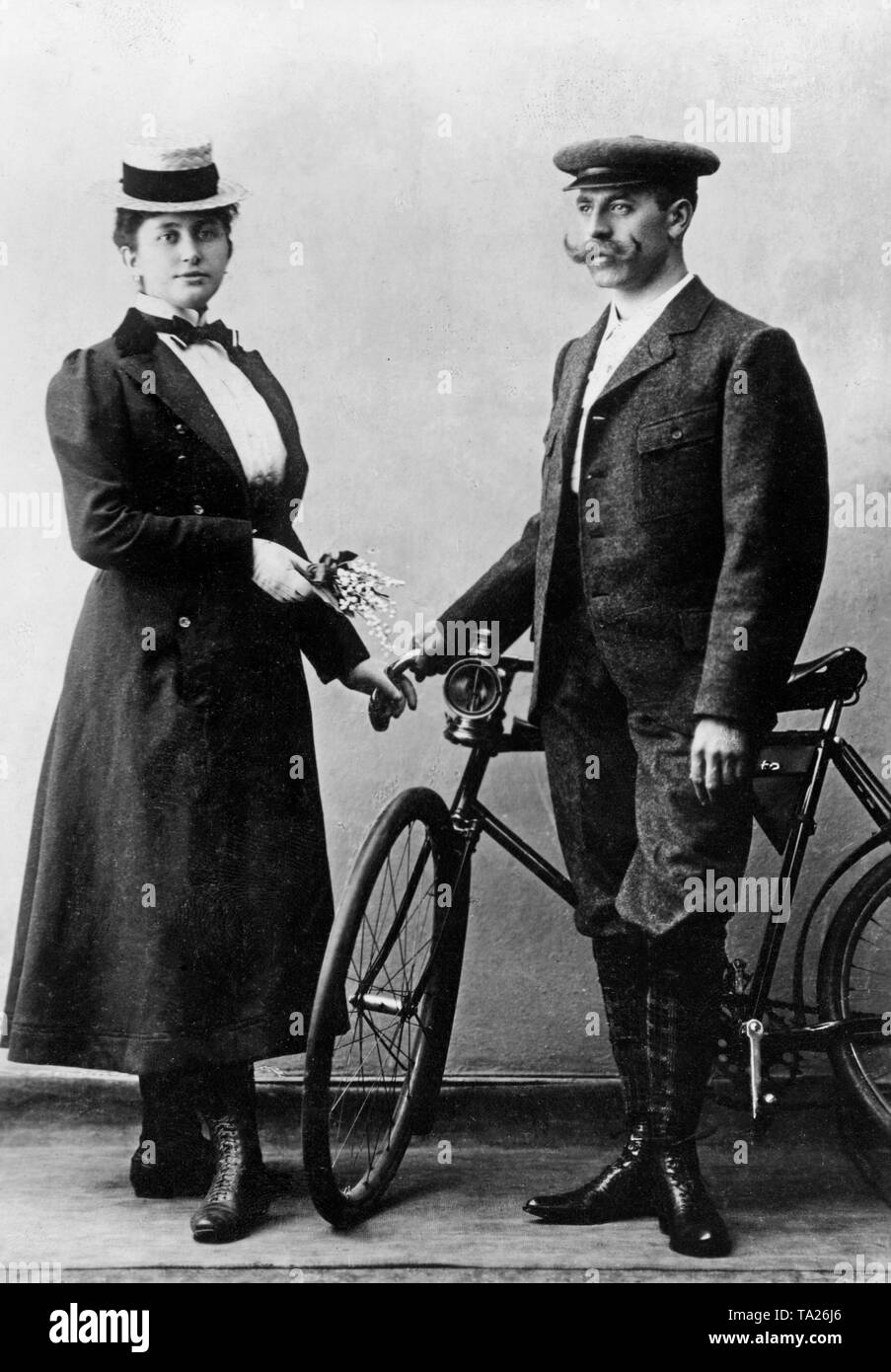 A couple is posing for a photo with a bike. Stock Photo