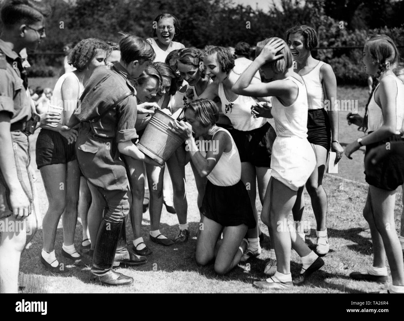 During the sports competitions in the Stadium Neukoelln at the Deutsches Jugendfest (German Festival of Youth) in Berlin, boys of the Hitlerjugend are bringing thirsty BDM girls water in buckets. Stock Photo