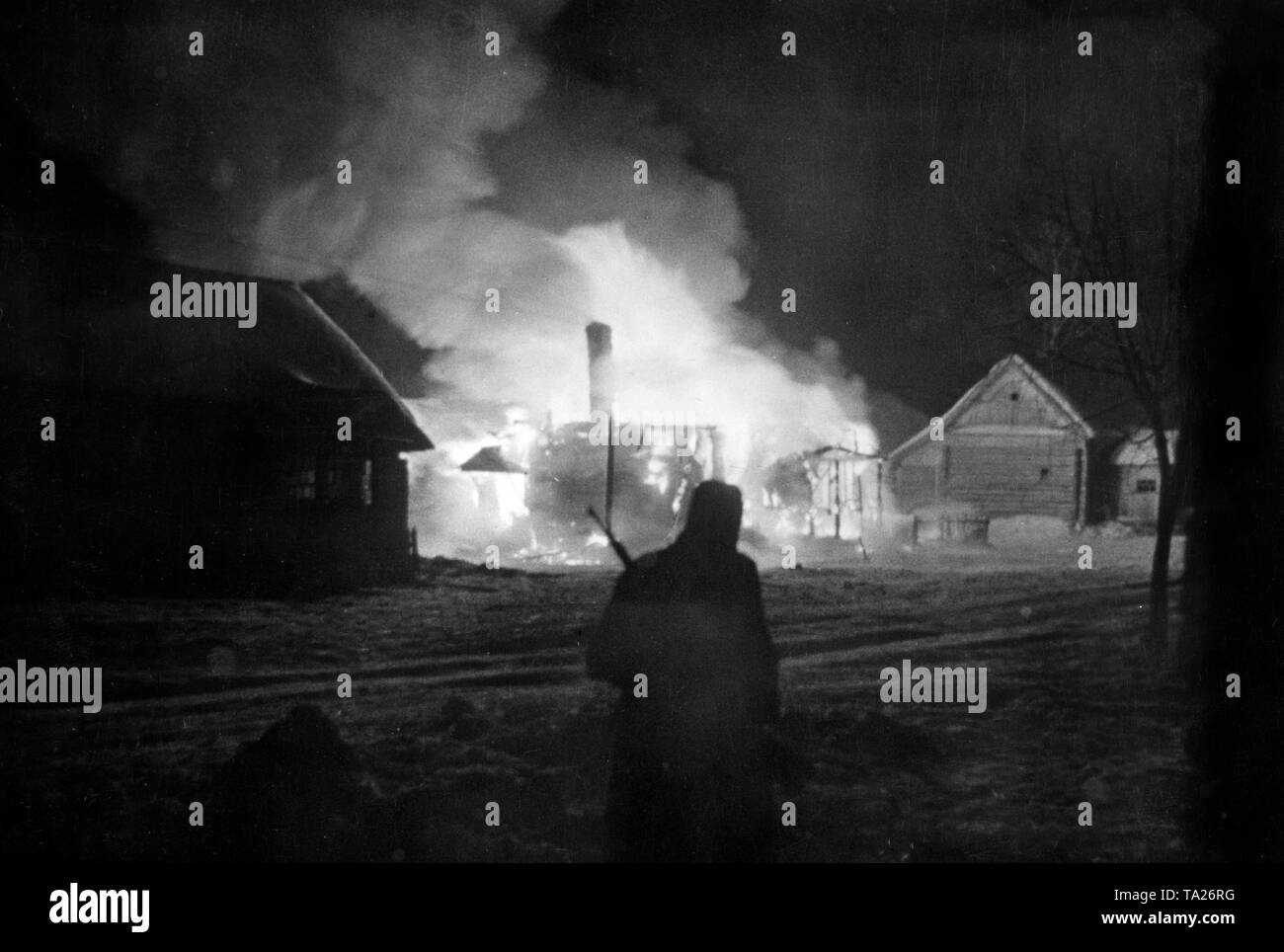 A German soldier at night in front of a burning Russian village west of Moscow. (PK-photo) Stock Photo