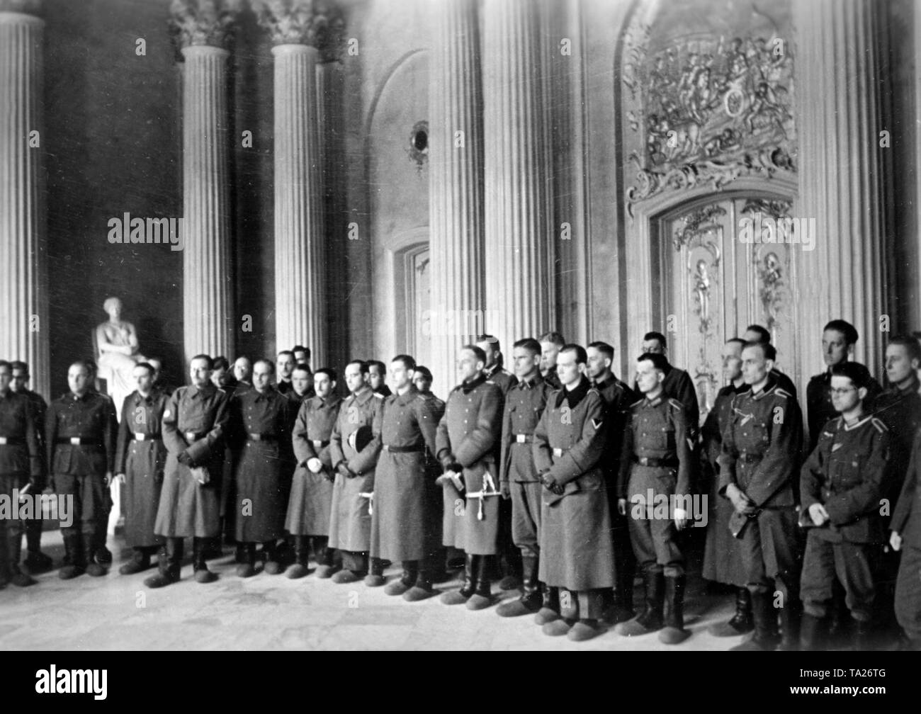 Soldiers from various nations who served in the Wehrmacht, Waffen-SS and foreign formations, during a visit to the New Palace in Potsdam within the scope of a propagandistic meeting of front-line soldiers. They wear the usual, parquet-friendly felt slippers above their boots. Stock Photo