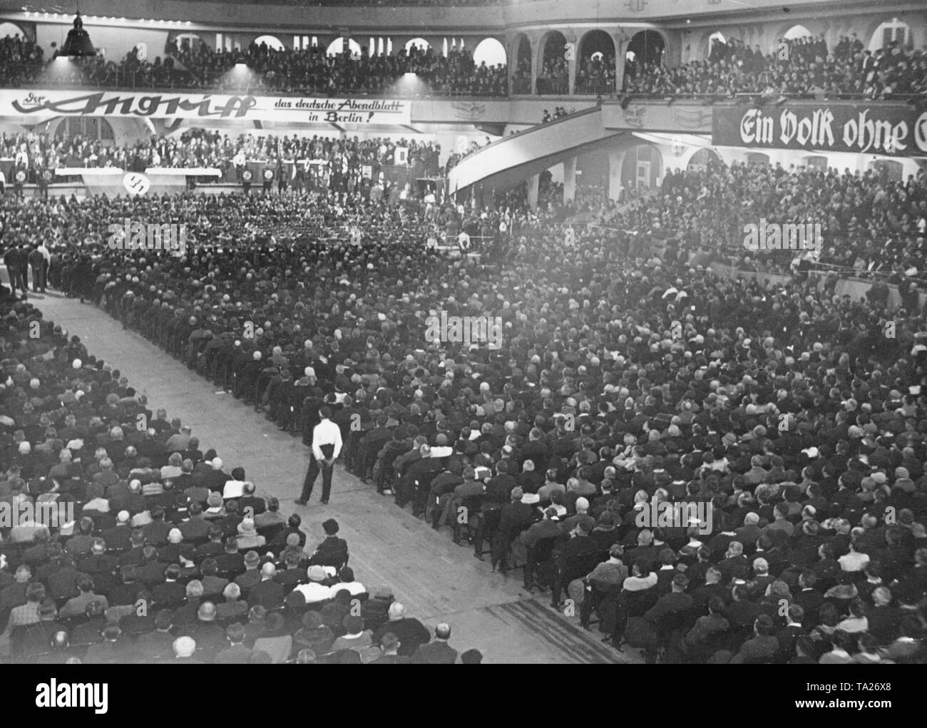 View of the audience at a meeting of the NSDAP in the Sportpalast in Berlin. In the aisle is an SA-man in white shirt. Stock Photo