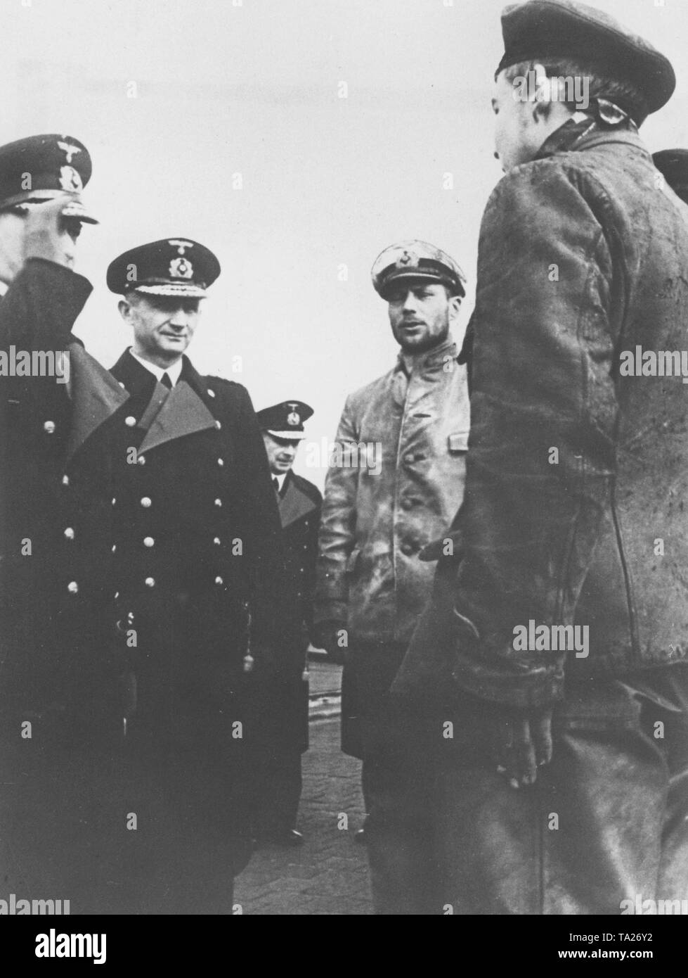 Grand Admiral Raeder and the Commander of the Submarines Doenitz (from left) greet a German submarine on her return to the base after a combat patrol against the enemy. Stock Photo