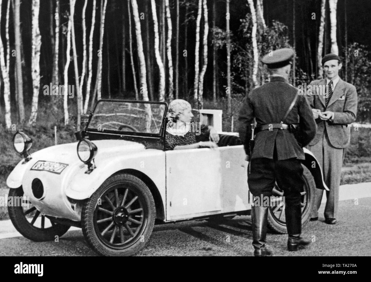 An official of the road service asks passengers of a Hanomag 2/10 hp Komissbrot to continue driving. Stock Photo