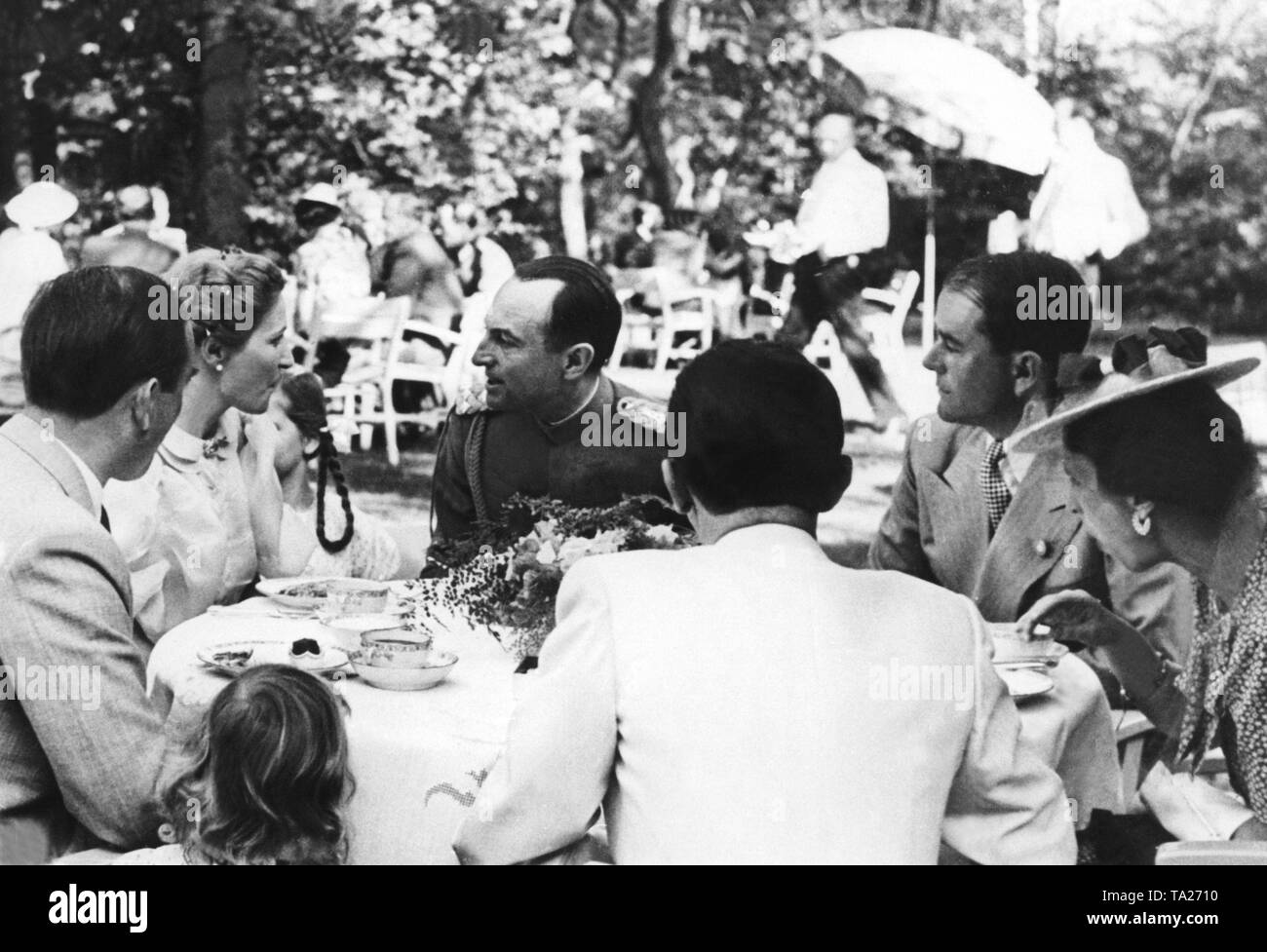 The Prince Regent Paul of Yugoslavia (center) visits Josh Goebbels (with his back to the camera) on his private property on the island of Schwanenwerder. Sitting at the table, the Prince Regent is talking to Magda Goebbels (to the left of him). Also at the table, Albert Speer (2nd from right) and the Prince Regent's wife Olga of Greece (right). Beside Magda and Joseph Goebbels, one of the daughters. Stock Photo