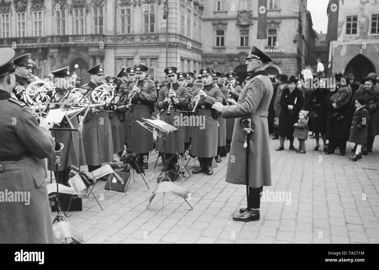 The military band of the Wehrmacht plays in Prague on the occasion of the hot pot at the Old Town Square. After the establishment of the Protectorate of Bohemia and Moravia, a stew event takes place once a month. Stock Photo
