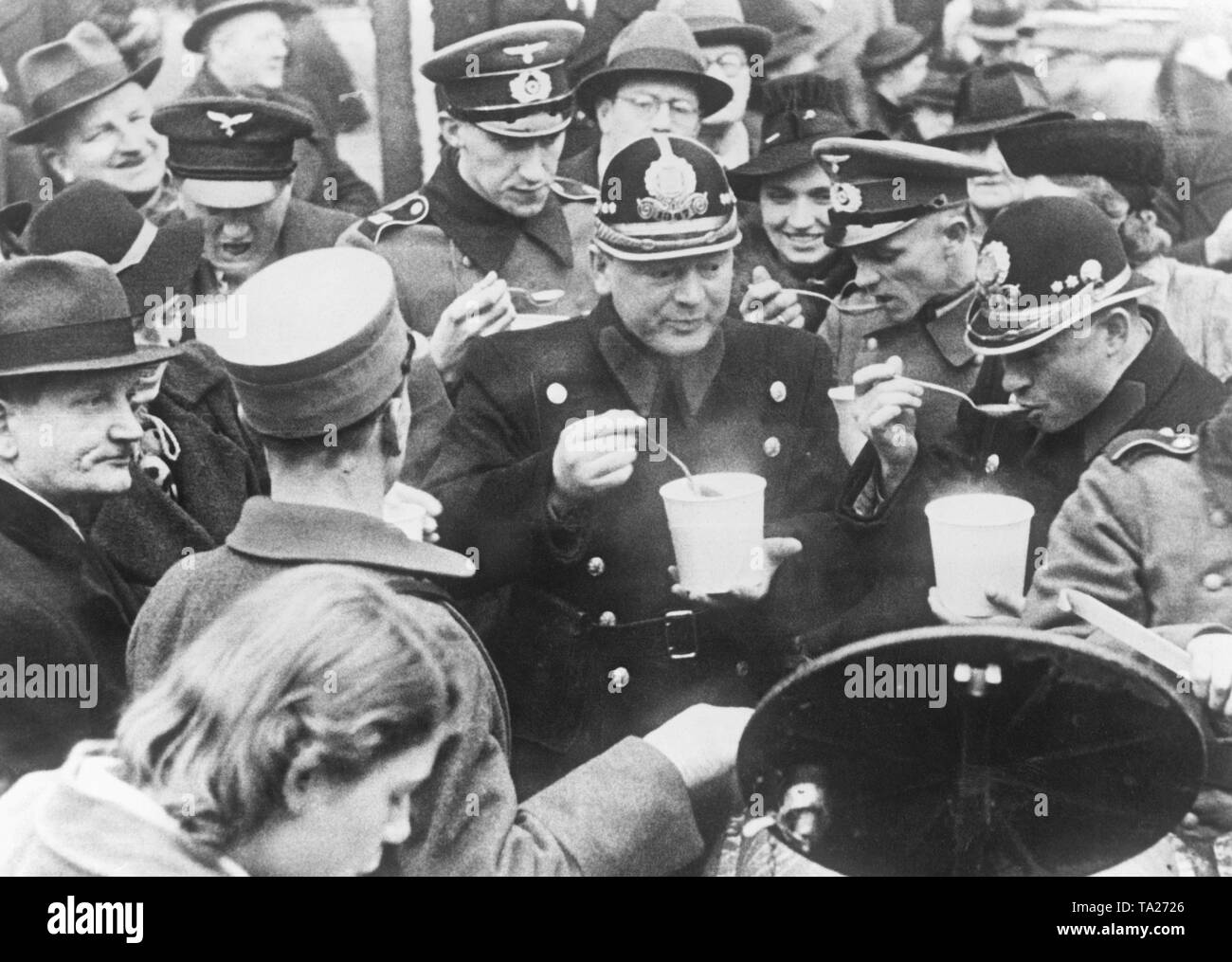 Stew Sunday of the Winterhilfswerk in Prague. After the establishment of the Protectorate of Bohemia and Moravia, the Stew Sunday takes place in Prague. Czech policemen eating soup. Stock Photo