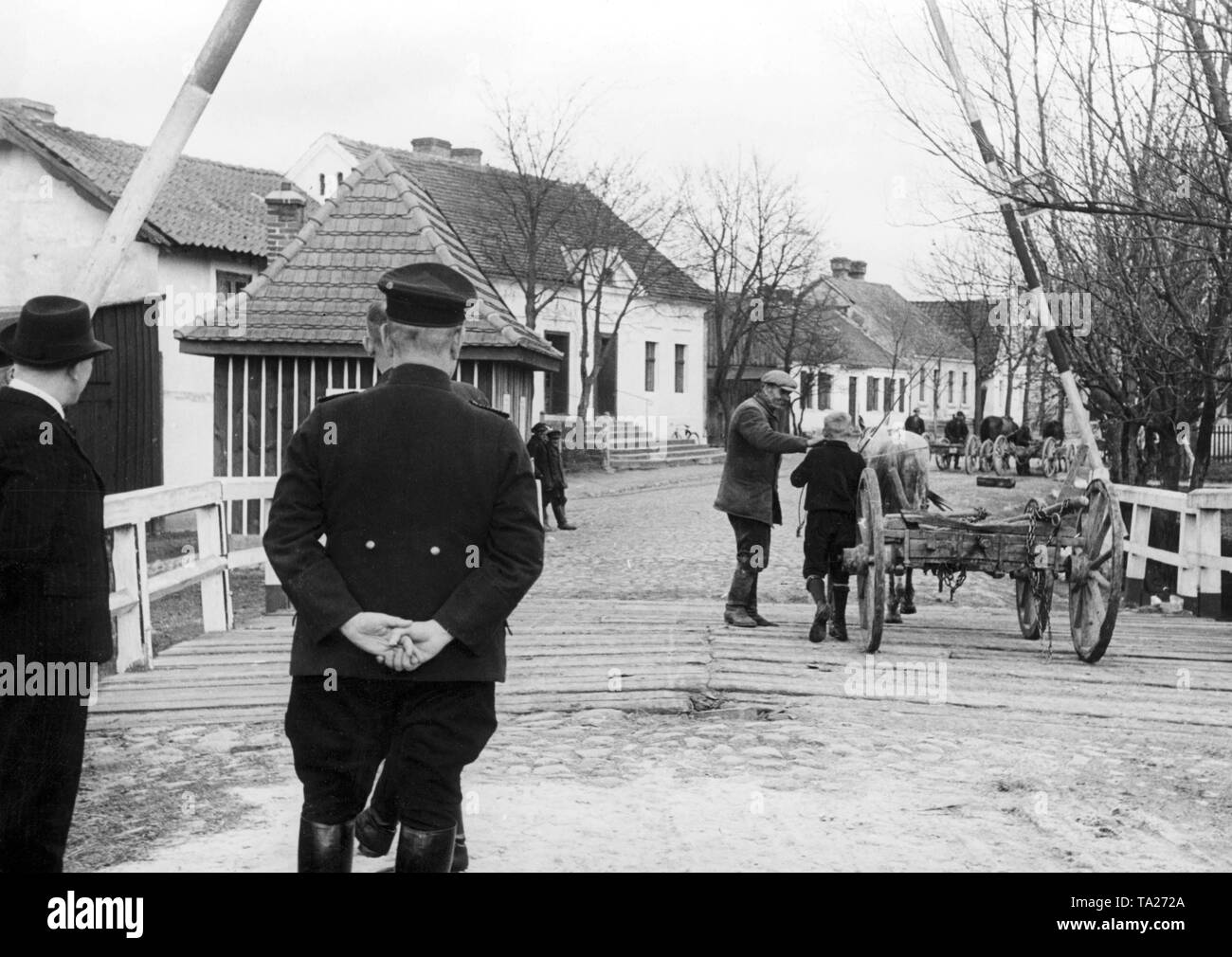 Border crossing at the German-Polish border in Bischofswerder, on the bridge are border guards, empty wagons are pulled by horses. Stock Photo