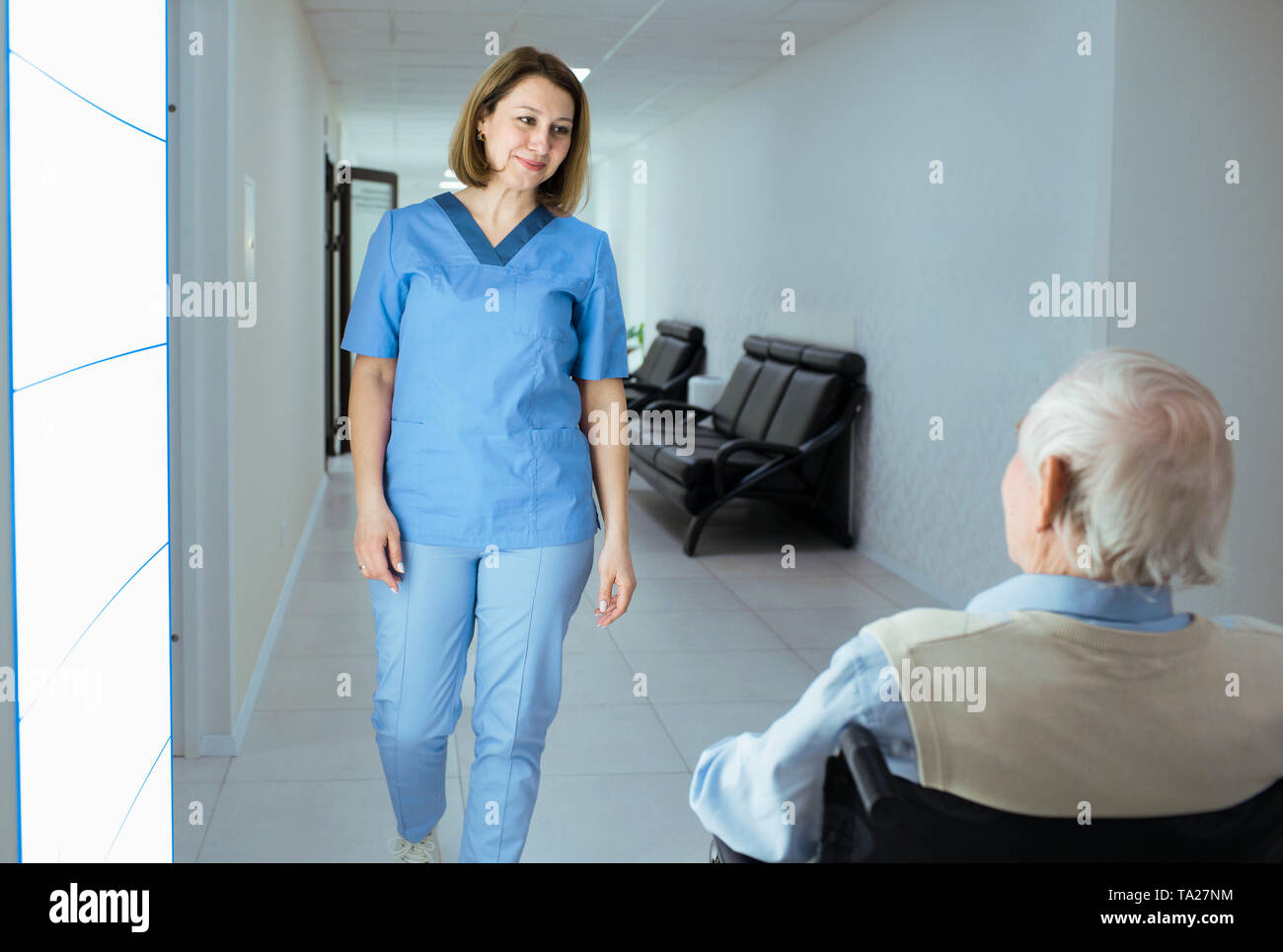 Friendly nurse and elderly man in the hospital corridor Stock Photo