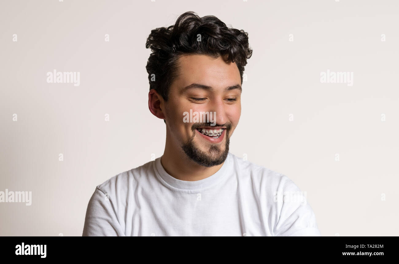 Portrait of a young man with braces smiling. A happy young man with ...