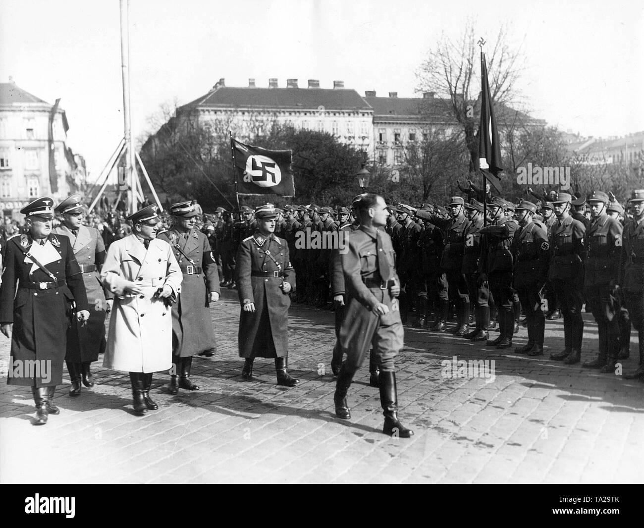 Reich Minister Rudolf Hess takes the salute of the Honour Guard of the NSDAP after his arrival at Vienna's Westbahnhof. On the left walks Gauleiter Josef Buerckel. Stock Photo