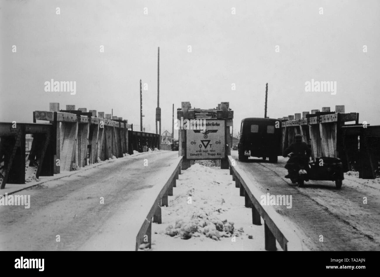 Trucks and motorcyclists travel across the Western Dvina (Daugava) through the Schwabenbruecke (Swabian bridge) built by Unit 11, Group 64 and the Todt Organization. The demolished bridge unit was replaced by a wooden construction. War reporter: Burkhardt. Stock Photo