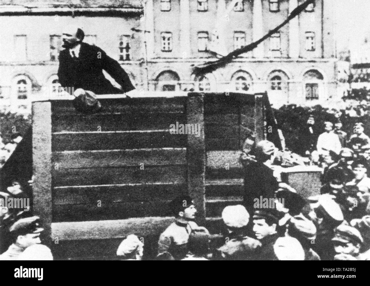 Vladimir Ilyich Lenin stands on a rostrum and gives a speech. Leon Trotsky, who actually stands on the stairway to the tribune, was airbrushed out from the public images as Stalin gained power. Stock Photo