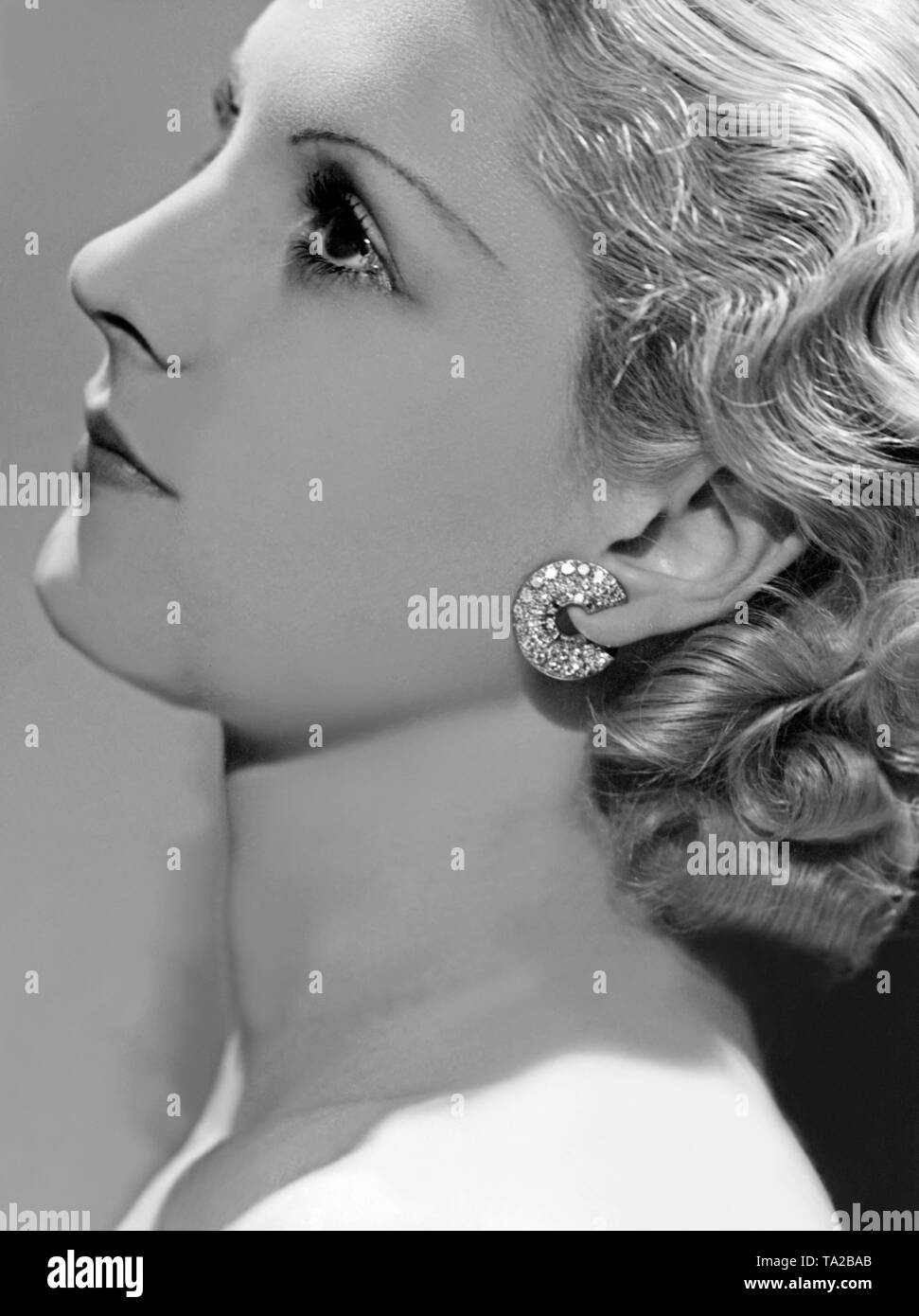 Woman portrait with contemporary hair fashion. The woman wears earrings of the brand 'Arpels & van Cleef'. Stock Photo