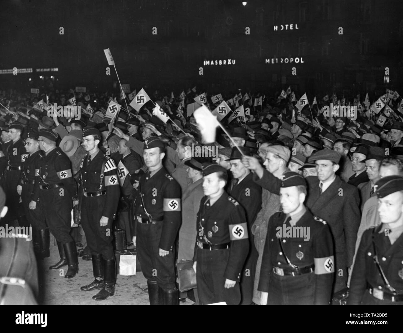After the Anschluss of Austria, Austrian workers participate in a Germany tour organized by the Nazi organization 'Kraft durch Freude'. Here, view of the arrival at the Muenchen Hauptbahnhof. In the foreground, men of a Nationalsozialistische Betriebszellenorganisation (National Socialist Factory Cell Organization, NSBO). In the background, letterings of the Thomasbrau and Hotel Metropol. Stock Photo