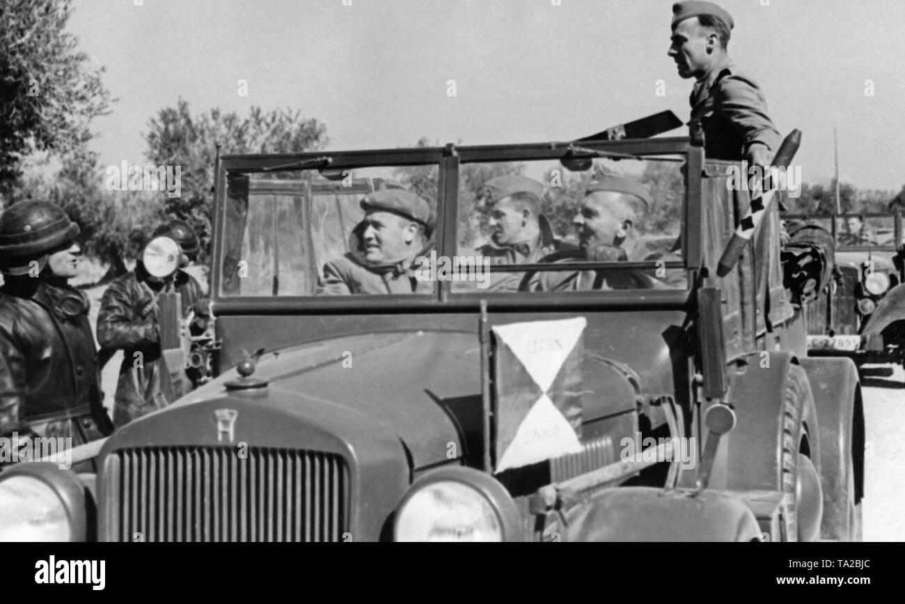 Photo of the command post vehicle, Horch 901 (motor vehicle 15) of the commander of the Condor Legion, major general Wolfram von Richthofen ( in the driver's seat, beside him staff officers). At the front, the red and yellow pennant of the Condor Legion, on the right side of the direction indicator, the pennant of the Chief of Staff. Richthofen is talking to an Italian tank commander in a leather suit. Stock Photo