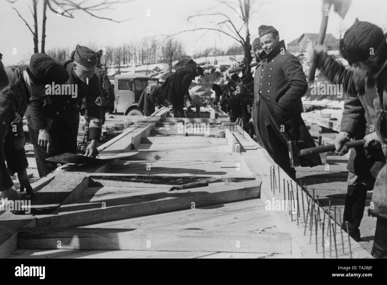 Workers of the Todt Organization are building a wooden bridge over a river (possibly Siwersky Donets) on the Eastern Front in the Soviet Union. Connectors that are supporting the roadways are nailed together. War reporter: Goetze. Stock Photo